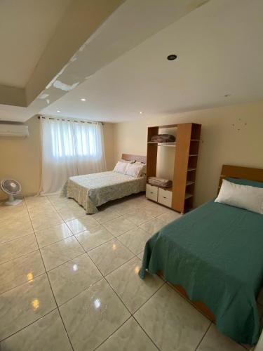 a bedroom with two beds and a tiled floor at Espaço dos Lobato in Miguel Pereira