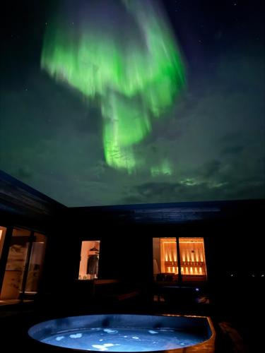 an image of the northern lights in the sky over a tub at NEW - Seafront Luxury Villa near Henningsvær in Kleppstad