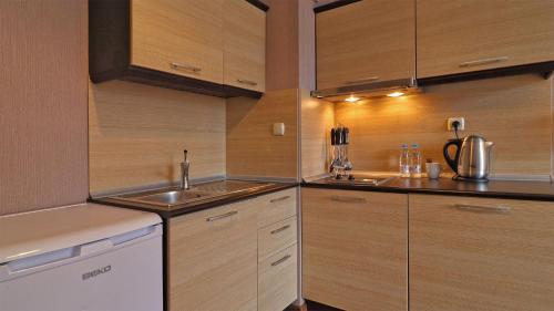 una cucina con mobili in legno e un lavello di SPA Suite a Bansko