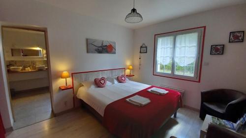 a bedroom with a bed with red sheets and a window at ENTRE LOIRE ET CHER Chambres d'Hôtes in Tour-en-Sologne