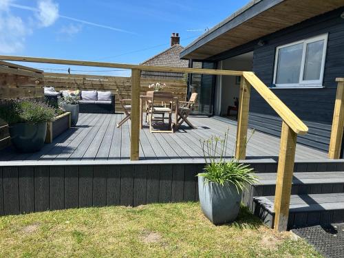 a deck with a table and chairs on a house at The Beach Hut in Perranporth