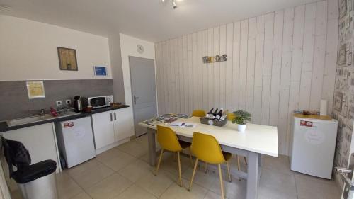 a kitchen with a white table and yellow chairs at ENTRE LOIRE ET CHER Chambres d'Hôtes in Tour-en-Sologne