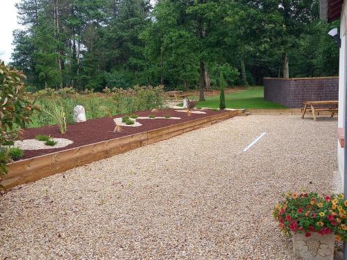 a garden with flowers and a bench in a yard at ENTRE LOIRE ET CHER Chambres d'Hôtes in Tour-en-Sologne