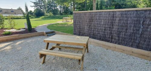 a wooden picnic table sitting next to a fence at ENTRE LOIRE ET CHER Chambres d'Hôtes in Tour-en-Sologne