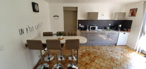 a kitchen with a table and chairs in a kitchen at ENTRE LOIRE ET CHER Grand Gîte "Côté Tilleul" in Tour-en-Sologne