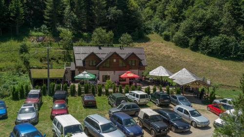 a bunch of cars parked in a parking lot in front of a house at Motel Luka in Deževice