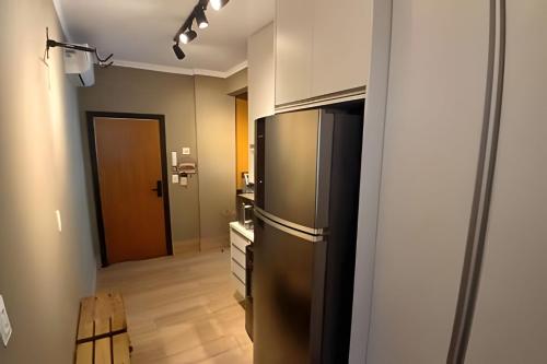 una cucina con un frigorifero in acciaio inossidabile in una stanza di SHB - Pé na Areia em Santos: Sol, Mar e Netflix a Santos