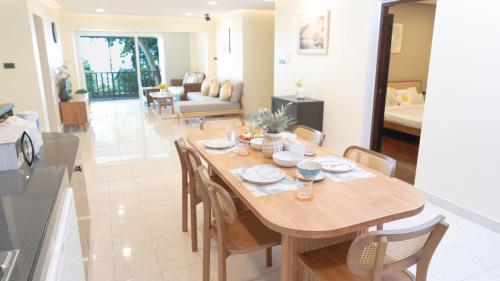 a dining room and living room with a wooden table and chairs at Jaokhun Hilltop Patong, Phuket in Patong Beach