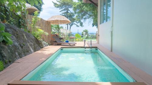 a swimming pool in the backyard of a house at Jaokhun Hilltop Patong, Phuket in Patong Beach