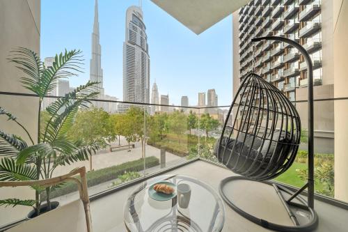 een kamer met een groot raam met een tafel en een stoel bij Luxury 2BR with Burj Khalifa Views l Near Dubai Mall in Dubai