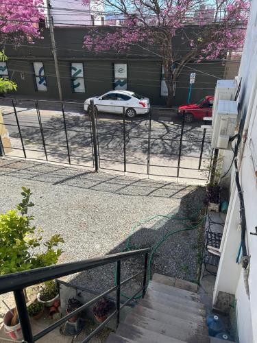 ein Zaun mit einem auf einem Parkplatz geparkten Auto in der Unterkunft Departamento Rojas 2 in San Fernando del Valle de Catamarca