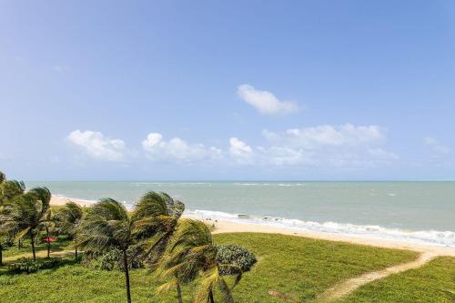 a beach with palm trees and the ocean at Alta Garden Housi João Pessoa by Carpediem in João Pessoa