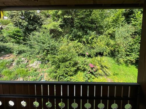 a view of a garden from a window with a bench at La cà dol Carlì in Clusone
