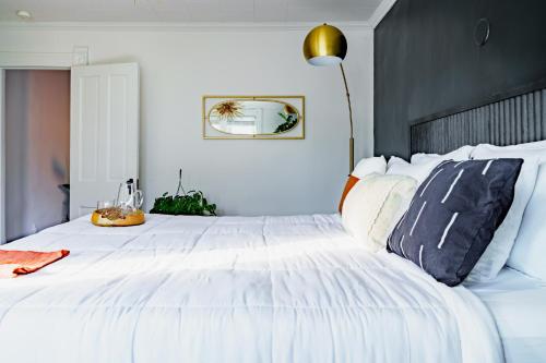 a white bedroom with a large white bed with pillows at Short North Convention King Bed Free Parking! in Columbus