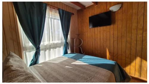 a bedroom with a window with a television and a bed at Algarrobo playa Canelo Cabaña opción Tinaja in Algarrobo