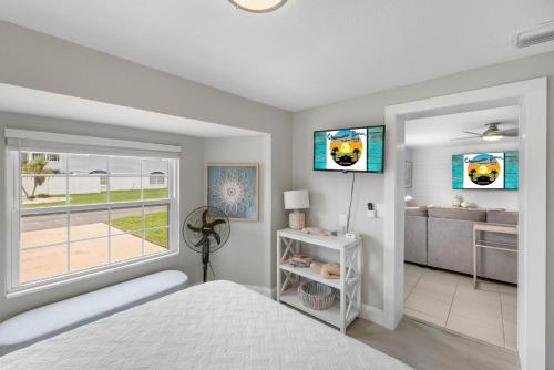 a bedroom with a bed and a bathroom with a window at Waterfront oasis with NEW POOL and kayaks in Hernando Beach