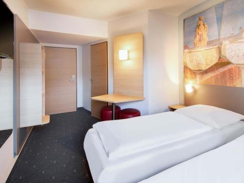 a hotel room with a bed and a desk at B&B Hotel Würzburg-City in Würzburg