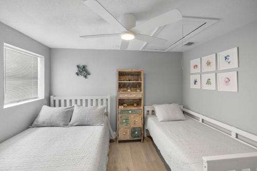 a bedroom with two beds and a ceiling fan at Waterfront oasis with NEW POOL and kayaks in Hernando Beach