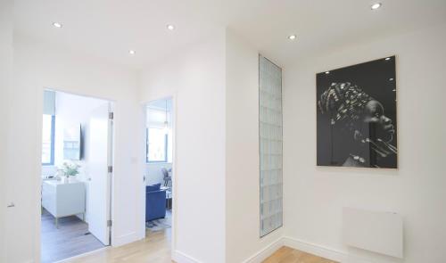 a room with white walls and a picture on the wall at Large City Centre Apartment Stylish and Spacious in Manchester
