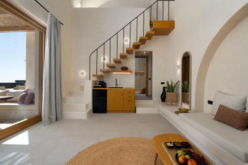a living room with a staircase in a house at Athera Luxury Villas in Santorini