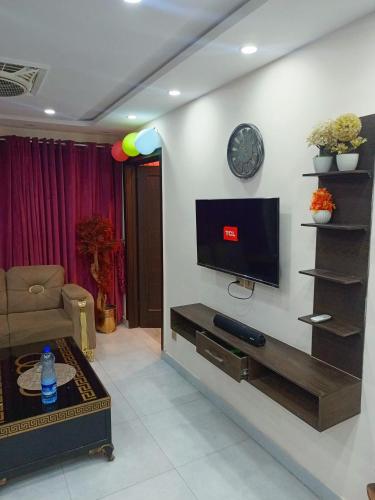 a living room with a flat screen tv on a wall at One bed apartment in Lahore in Lahore