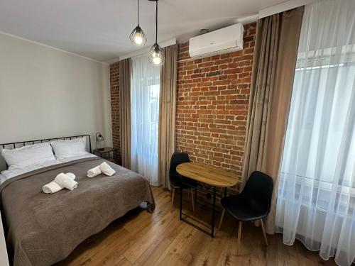 a bedroom with a bed and a brick wall at Kamienica LOFT in Ciechocinek