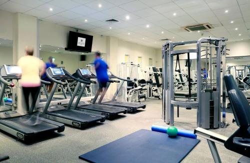 a gym with rows of tread machines and people in it at Macdonald Botley Park Hotel & Spa in Southampton