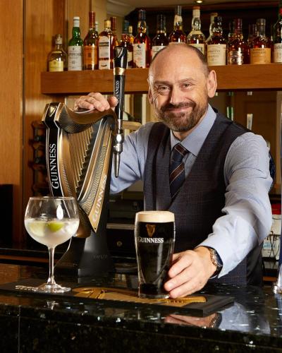 a man sitting at a bar with a glass of wine at Macdonald Botley Park Hotel & Spa in Southampton