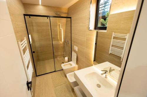a bathroom with a sink and a shower and a toilet at Lakeside Villas in Široka