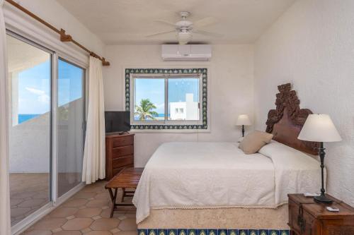 a bedroom with a bed and a window and a television at Casa del Mar in Akumal