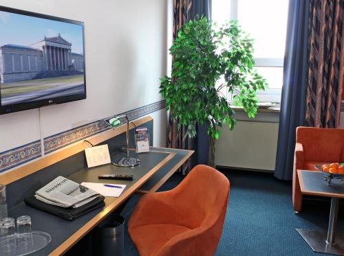 a room with a desk with a television and a chair at AMBER ECONTEL in Munich
