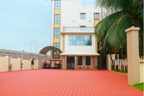 a building with a red brick driveway in front of a building at Hotel Radhika in Somnath
