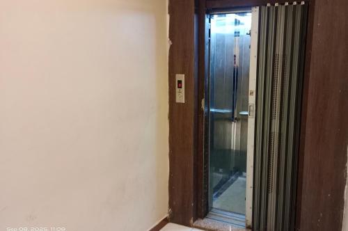 a glass door to a shower in a room at Hotel Radhika in Somnath