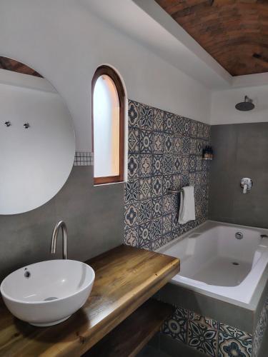a bathroom with a white sink and a tub at La Alhambra Hotel Boutique in Villa de Leyva