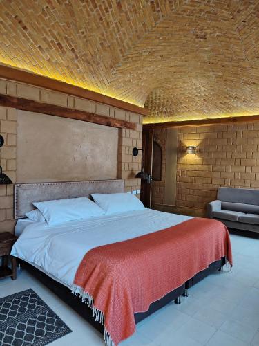 a bedroom with a large bed and a couch at La Alhambra Hotel Boutique in Villa de Leyva