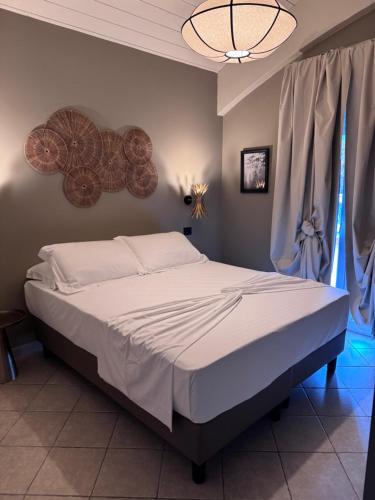 a bedroom with a large bed with white sheets at Rock Crystal Boutique Hotel in Gabicce Mare