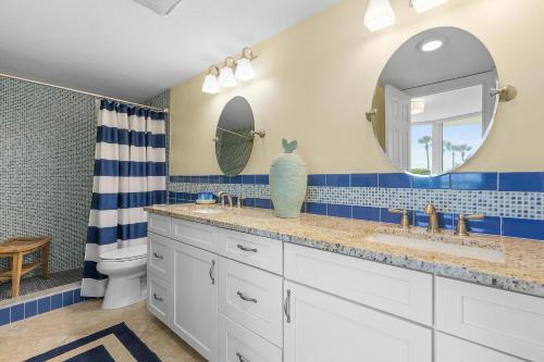 a bathroom with two sinks and a toilet and a mirror at Golden Arms 101 in Chicken Island