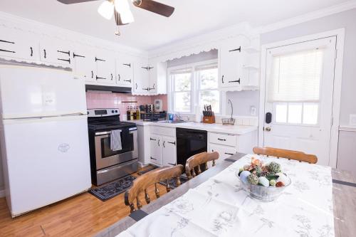 a kitchen with white appliances and a table with a bowl of fruit at Florence in Milford