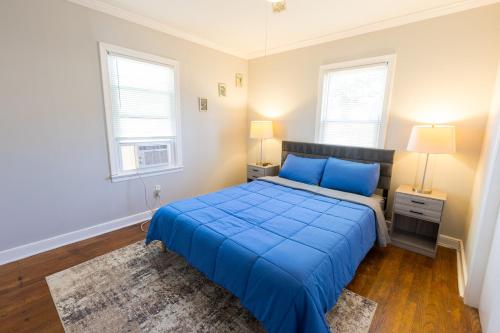 a bedroom with a blue bed and two windows at Florence in Milford