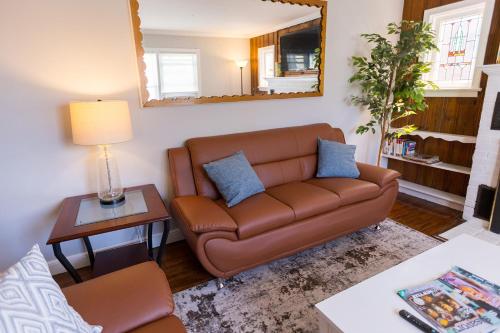 a living room with a brown couch and a mirror at Florence in Milford