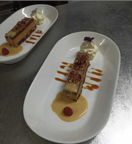 a white plate with a piece of dessert on a table at La Sapinière St Lary Soulan in Saint-Lary-Soulan