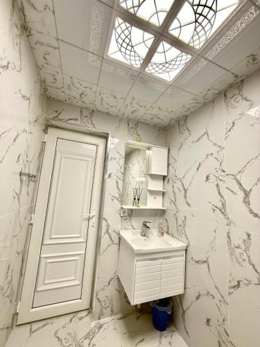 a white bathroom with a sink and a window at Villa Gabala in Gabala