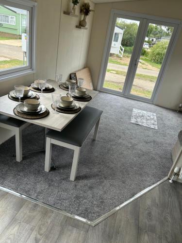 a dining room with a table with plates and glasses at Billing Aquadrome holiday park - sleeps up to 7 in Great Billing
