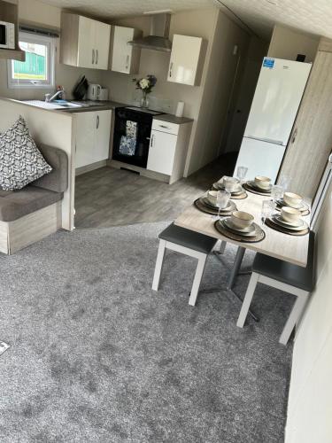a living room with a table and a kitchen at Billing Aquadrome holiday park - sleeps up to 7 in Great Billing