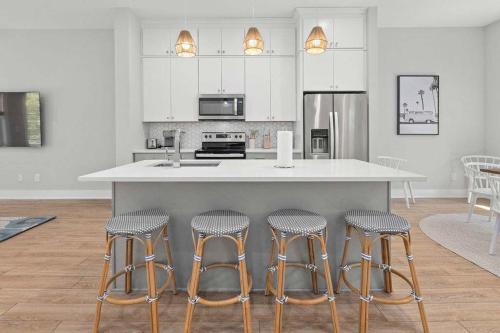 eine Küche mit einer Insel mit vier Barhockern in der Unterkunft Sincerely Shem III- 7 min to beach and dtwn CHS in Charleston