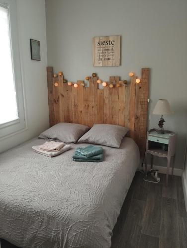 a bedroom with a large bed with a wooden headboard at Appartement avec Vue sur Mer in Criel-sur-Mer