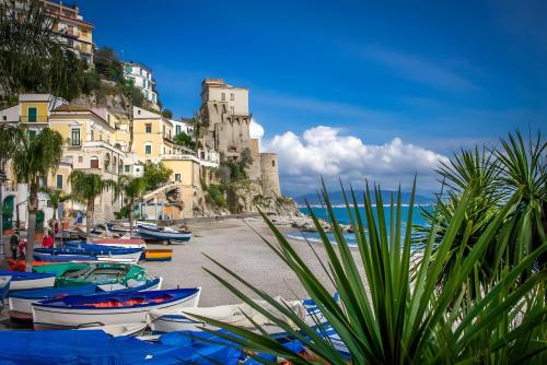 a group of boats on a beach with buildings at Ce Tour - Cetara Guest House in Cetara