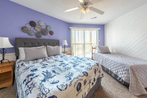 a bedroom with a bed and a ceiling fan at K1410 Loggerhead Landing - Oceanside Condo Just Steps to the Beach! in Croatan Shores