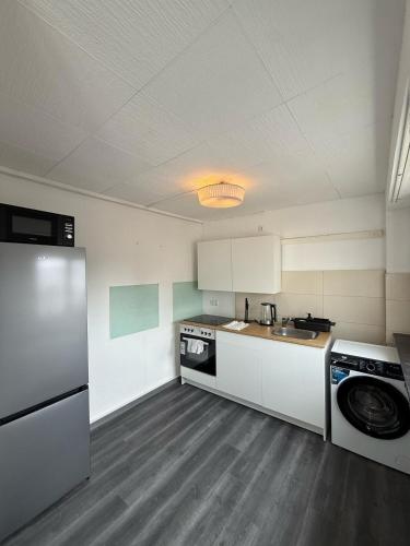 a kitchen with white cabinets and a washer at Spacious Apartment in Mörfelden-Walldorf in Mörfelden-Walldorf