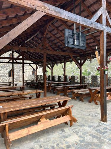 a group of wooden picnic tables in a pavilion at Castel Templul Cavalerilor in Vălişoara